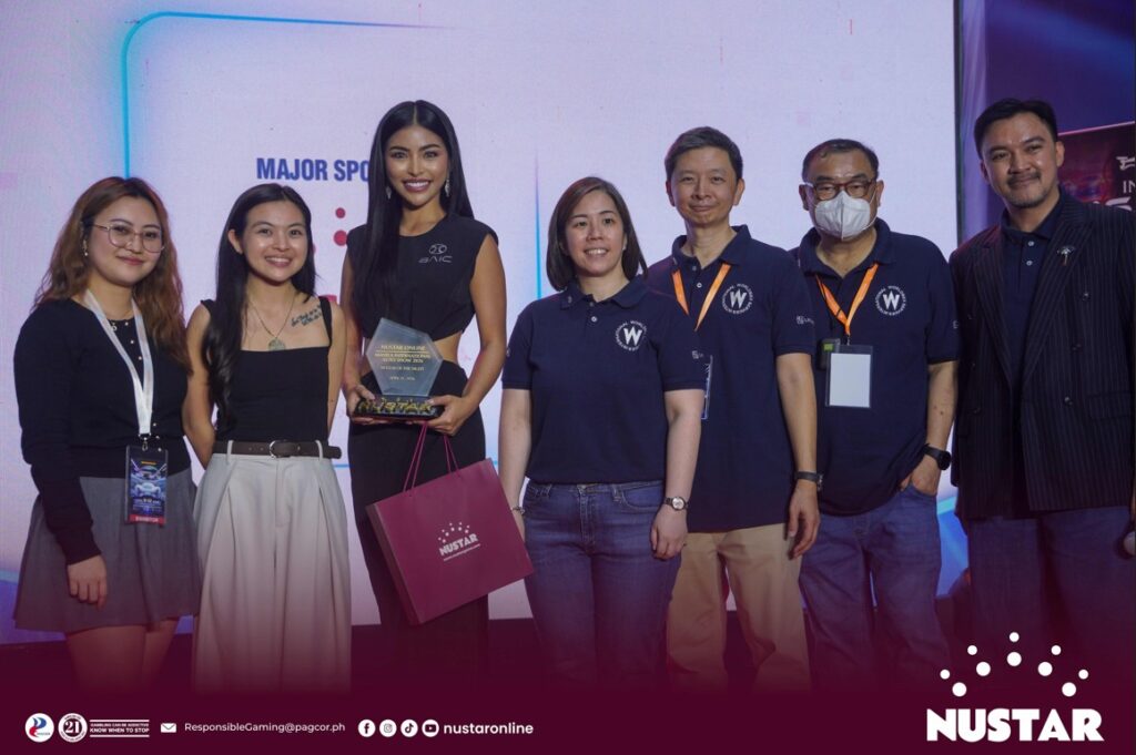 nustar online representatives (two from left) and mias 2026 organizers (four from right) present the “nustar of the night” award to bea ocampo, shown holding the plaque