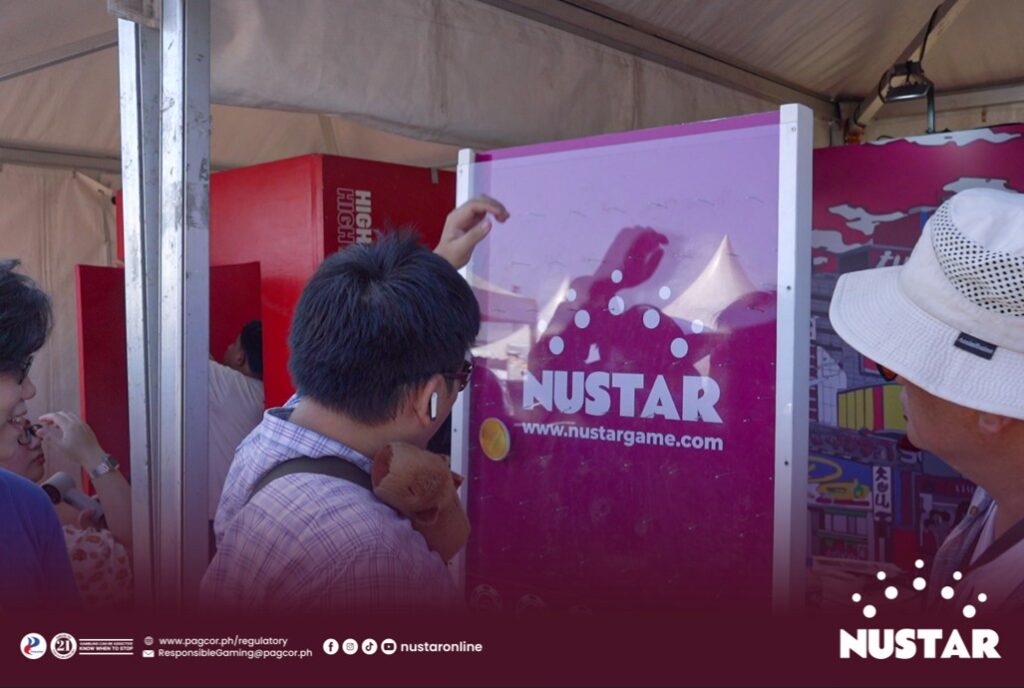 festival attendee enjoys playing plinko at the nustar online booth