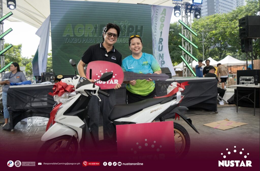 nustar online brand manager alexander barcela with the grand raffle winner of a brand new motorcycle