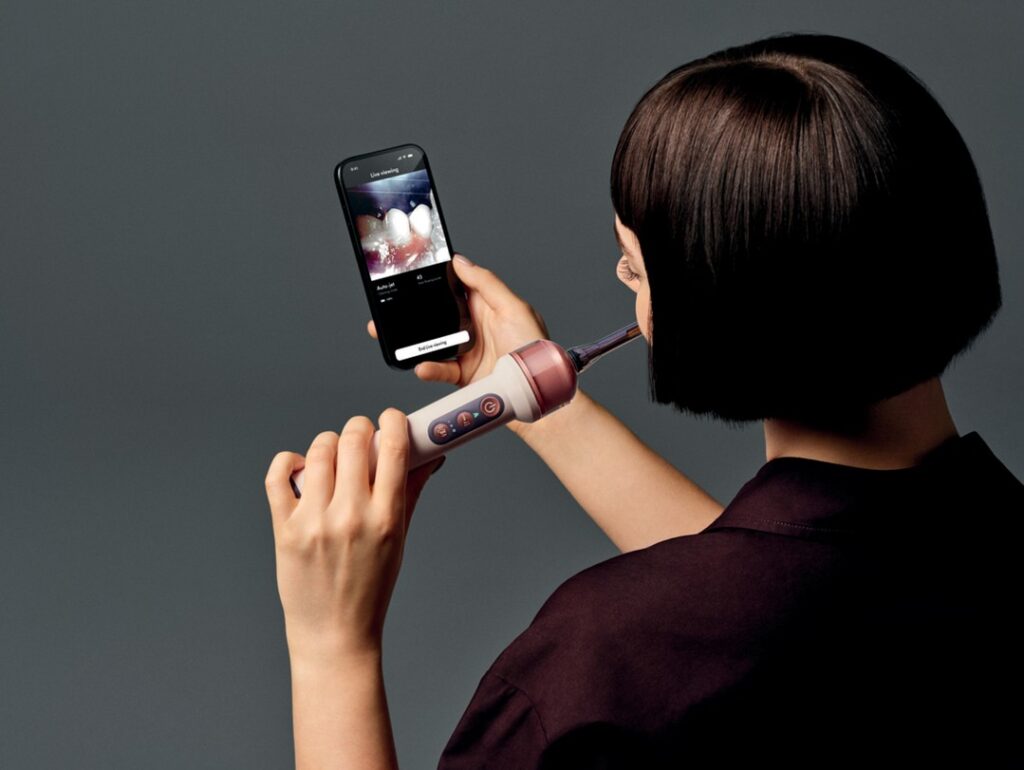 Dyson CameraJet Brings AI and a Built-In Camera to the Future of Oral Care oc01 ppidrossvl 062 cmyk inuse talent female west phoneinhand appscreen a1 mono